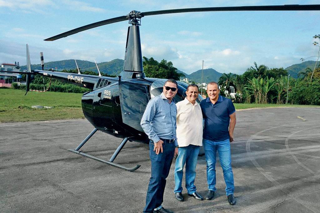 Eurípedes posando para foto com o helicoptero que comprou com dinheiro do partido.