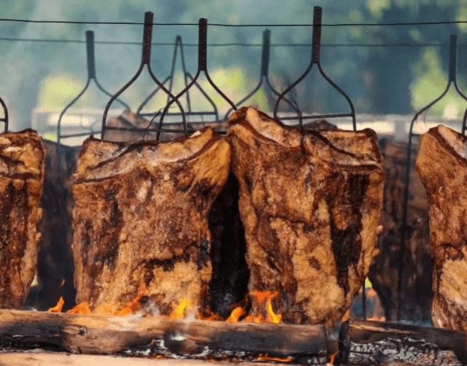 Foto de costela sendo assada na brasa no chão